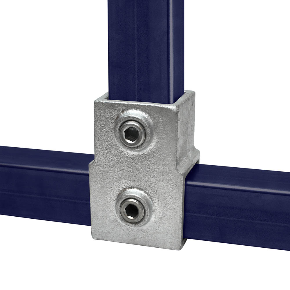 Robuster, silberner T-Stück-Verbinder aus Metall, verbindet zwei dunkelblaue, quadratische Rohre. Ein Rohr liegt horizontal, das zweite wird vertikal von oben eingefügt. Zwei Sechskantschrauben sichern 40-mm-Rohre.